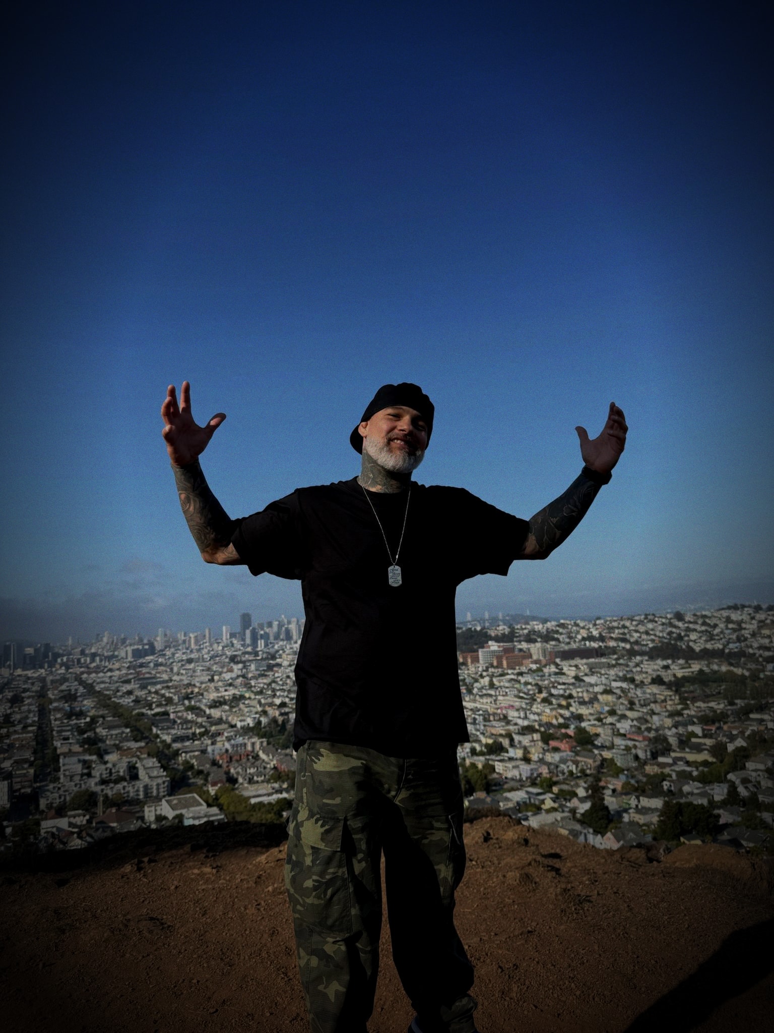 Johnny, the founder of 25 Two Life, standing above the city with his arms raised